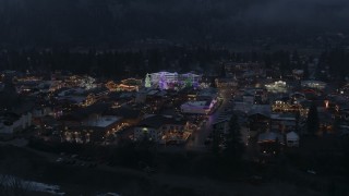 DX0002_228_001 - 5.7K aerial stock footage of orbiting a small town with Christmas trees and lights at twilight, Leavenworth, Washington