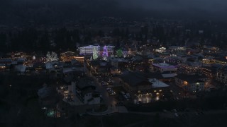 DX0002_228_002 - 5.7K aerial stock footage of circling a small town with Christmas trees and lights at twilight, Leavenworth, Washington