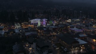 DX0002_228_003 - 5.7K aerial stock footage of an orbit of a small town with Christmas trees and lights at twilight, Leavenworth, Washington