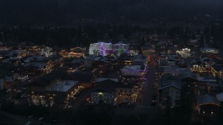 DX0002_228_004 - 5.7K aerial stock footage of flying around a small town with Christmas trees and lights at twilight, Leavenworth, Washington