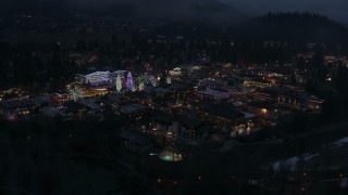 DX0002_228_009 - 5.7K aerial stock footage of an orbit of Christmas trees and lights at night in Leavenworth, Washington