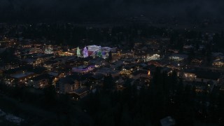 DX0002_228_012 - 5.7K aerial stock footage of slowly approaching Christmas trees and lights at night in Leavenworth, Washington