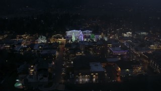 DX0002_228_015 - 5.7K aerial stock footage slowly orbit town with Christmas trees and lights at night in Leavenworth, Washington