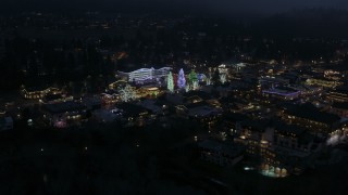 DX0002_228_016 - 5.7K aerial stock footage slowly circling Christmas trees and lights at night in Leavenworth, Washington