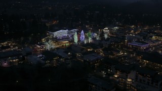 DX0002_228_017 - 5.7K aerial stock footage of orbiting Christmas trees and lights at night in Leavenworth, Washington