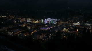DX0002_228_020 - 5.7K aerial stock footage reverse view of Christmas trees and lights at night, descend behind trees, Leavenworth, Washington