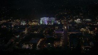 DX0002_228_026 - 5.7K aerial stock footage circling trees and buildings with Christmas lights at night, Leavenworth, Washington