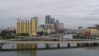 DX0003_229_038 - 5.7K aerial stock footage fly over a bridge and ascend toward the city skyline behind a condo complex, Downtown Tampa, Florida