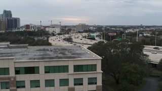DX0003_231_001 - 5.7K aerial stock footage ascend near office building to reveal freeway traffic in Tampa, Florida