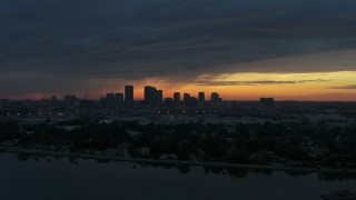 DX0003_231_047 - 5.7K stock footage aerial video ascend over McKay Bay while focused on the Downtown Tampa skyline at sunset, Florida