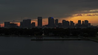DX0003_232_011 - 5.7K stock footage aerial video ascend from the bay toward the Downtown Tampa skyline at twilight, Florida