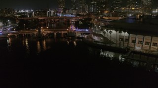 DX0003_232_055 - 5.7K aerial stock footage fly away from police cars on a bridge by convention center at night in Downtown Tampa, Florida