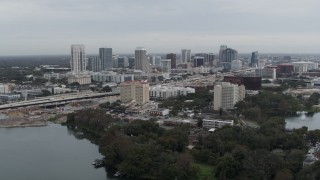DX0003_233_008 - 5.7K aerial stock footage of the city's skyline seen from Lake Concord, Downtown Orlando, Florida