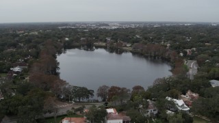 DX0003_233_011 - 5.7K aerial stock footage of a reverse view of waterfront homes around Lake Adair, Orlando, Florida