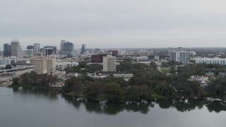 DX0003_233_023 - 5.7K aerial stock footage of office building by a lake, city's skyline in the background, Downtown Orlando, Florida