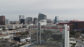 DX0003_233_042 - 5.7K aerial stock footage ascend by hotel for view of office and apartment buildings, Downtown Orlando, Florida