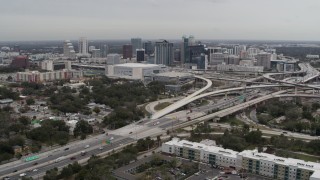 DX0003_234_001 - 5.7K aerial stock footage of Amway Center, city skyline, and freeway interchange, Downtown Orlando, Florida