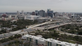 DX0003_234_006 - 5.7K aerial stock footage reverse view of Amway Center, city skyline, freeway interchange, Downtown Orlando, Florida