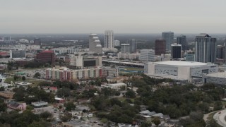 DX0003_234_021 - 5.7K aerial stock footage of flying by apartment complex, Amway Center and city skyline, Downtown Orlando, Florida
