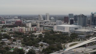 DX0003_234_022 - 5.7K aerial stock footage descend by apartment complex, Amway Center and city skyline, Downtown Orlando, Florida