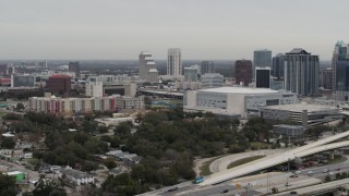 DX0003_234_024 - 5.7K aerial stock footage flying by apartment complex, Amway Center and city skyline, Downtown Orlando, Florida