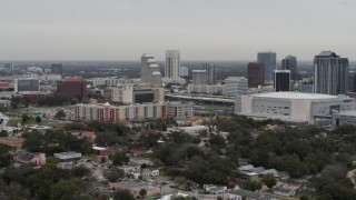 DX0003_234_025 - 5.7K aerial stock footage passing by apartment complex near Amway Center and city skyline, Downtown Orlando, Florida