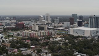 DX0003_234_026 - 5.7K aerial stock footage flying past apartment complex near Amway Center and city skyline, Downtown Orlando, Florida