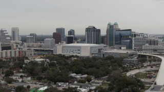 DX0003_234_030 - 5.7K aerial stock footage descend past Amway Center arena and city skyline, Downtown Orlando, Florida