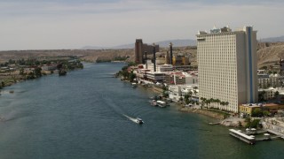 FG0001_000004 - 4K aerial stock footage fly over a ferry on the Colorado River to pass riverfront hotels and casinos in Laughlin, Nevada