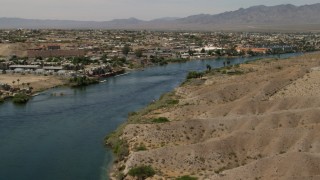 FG0001_000010 - 4K aerial stock footage follow the Colorado River to approach riverfront homes and apartments in Bullhead City, Arizona