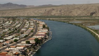 FG0001_000016 - 4K aerial stock footage follow a bend in the Colorado River past waterfront houses and docks in Bullhead City, Arizona