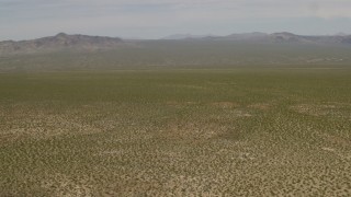 FG0001_000032 - 4K aerial stock footage tilt to reveal distant mountains and fly over open Mojave Desert in Laughlin, Nevada
