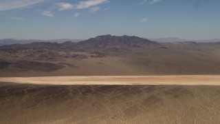 FG0001_000060 - 4K aerial stock footage approach a dry lake near Mojave Desert mountains in San Bernardino County, California