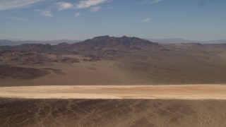 FG0001_000061 - 4K aerial stock footage of a slow approach to a dry lake near Mojave Desert mountains in San Bernardino County, California