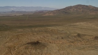 FG0001_000103 - 4K aerial stock footage pan across desert plain and road near Rodman Mountains in the Mojave Desert, San Bernardino County, California