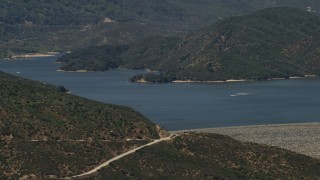FG0001_000128 - 4K aerial stock footage approach the lake and dam as speedboats cruise across Silverwood Lake, California