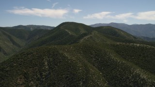FG0001_000163 - 4K aerial stock footage approach and fly over a green mountain ridge in the San Gabriel Mountains, California