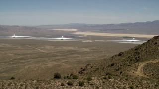 FG0001_000165 - 4K aerial stock footage of towers and arrays of the Ivanpah Solar Electric Generating System, California, eclipsed by mountain