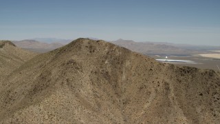FG0001_000170 - 4K aerial stock footage approach desert mountain near the Ivanpah Solar Electric Generating System in California