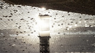FG0001_000208 - 4K aerial stock footage of a close-up view of a glowing power tower boiler at the Ivanpah Solar Electric Generating System in California