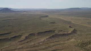 FG0001_000238 - 4K aerial stock footage flyby a mesa overlooking desert road and plain in the Arizona Desert