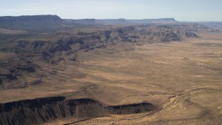 FG0001_000245 - 4K aerial stock footage of rugged mesas overlooking a wide plain in the Arizona Desert