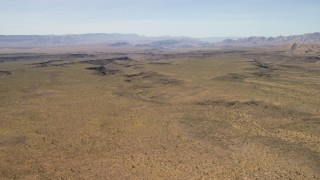 FG0001_000246 - 4K aerial stock footage of a wide plain and canyons in the Arizona Desert