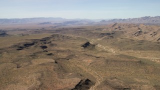 FG0001_000248 - 4K aerial stock footage of a wide canyon through the desert plain in the Arizona Desert