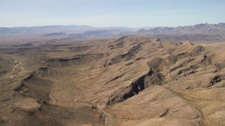 FG0001_000249 - 4K aerial stock footage of a wide canyon through the desert by mountains in the Arizona Desert