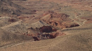 FG0001_000253 - 4K aerial stock footage of sheer red slopes of rocky hills around a shallow box canyon in the Nevada Desert