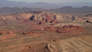 FG0001_000258 - 4K stock footage aerial video of red rock formations near a mountain ridge in the Nevada Desert