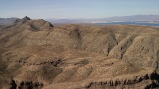 FG0001_000261 - 4K aerial stock footage of steep-sloped mountain ridges in the Nevada Desert and Lake Mead in the background