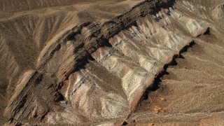 FG0001_000266 - 4K aerial stock footage tilt to a bird's eye view of a scarred hillside in the Nevada Desert