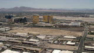 FG0001_000352 - 4K aerial stock footage of an open dirt lot beside I-15 with light traffic in Las Vegas, Nevada and casino resorts on the Strip